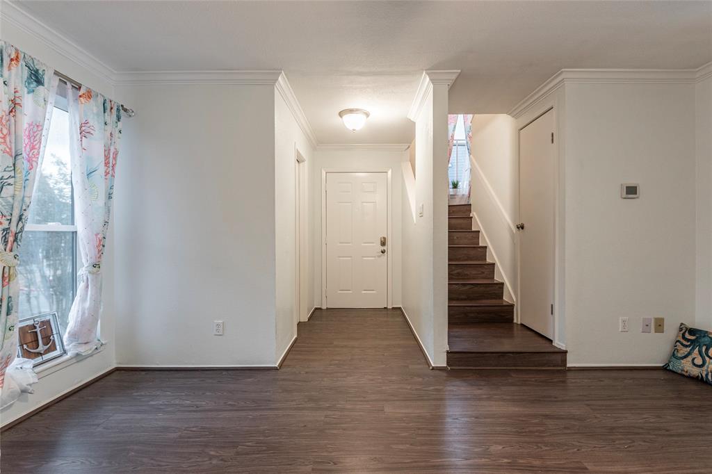 a view of a hallway with wooden floor and entryway