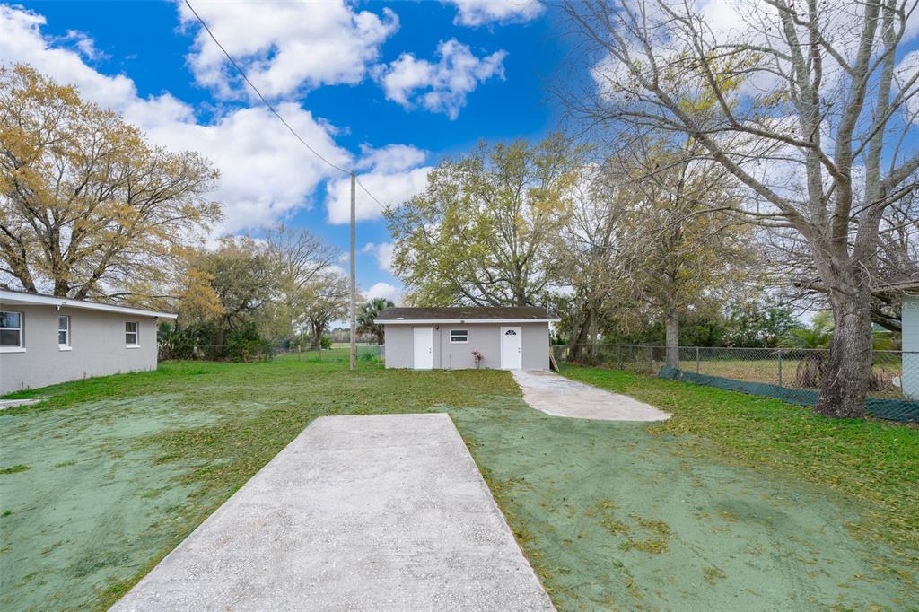 a view of a house with backyard and trees