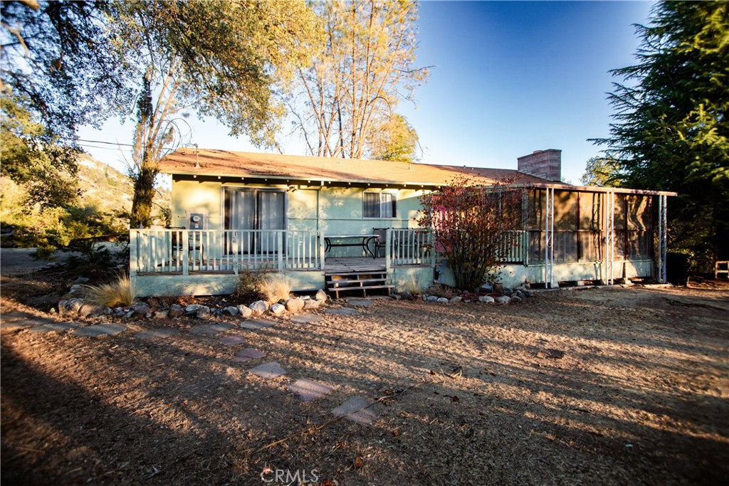 a backyard of a house with barbeque oven table and chairs