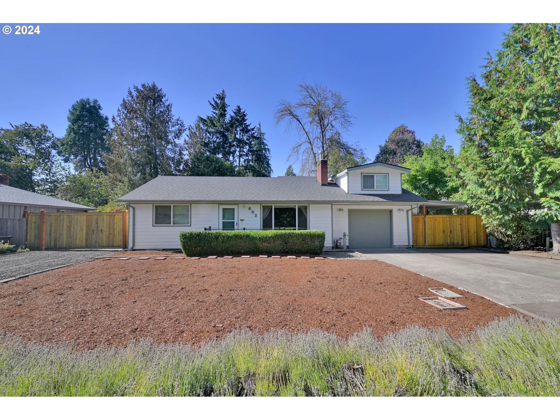 a front view of a house with a yard and trees