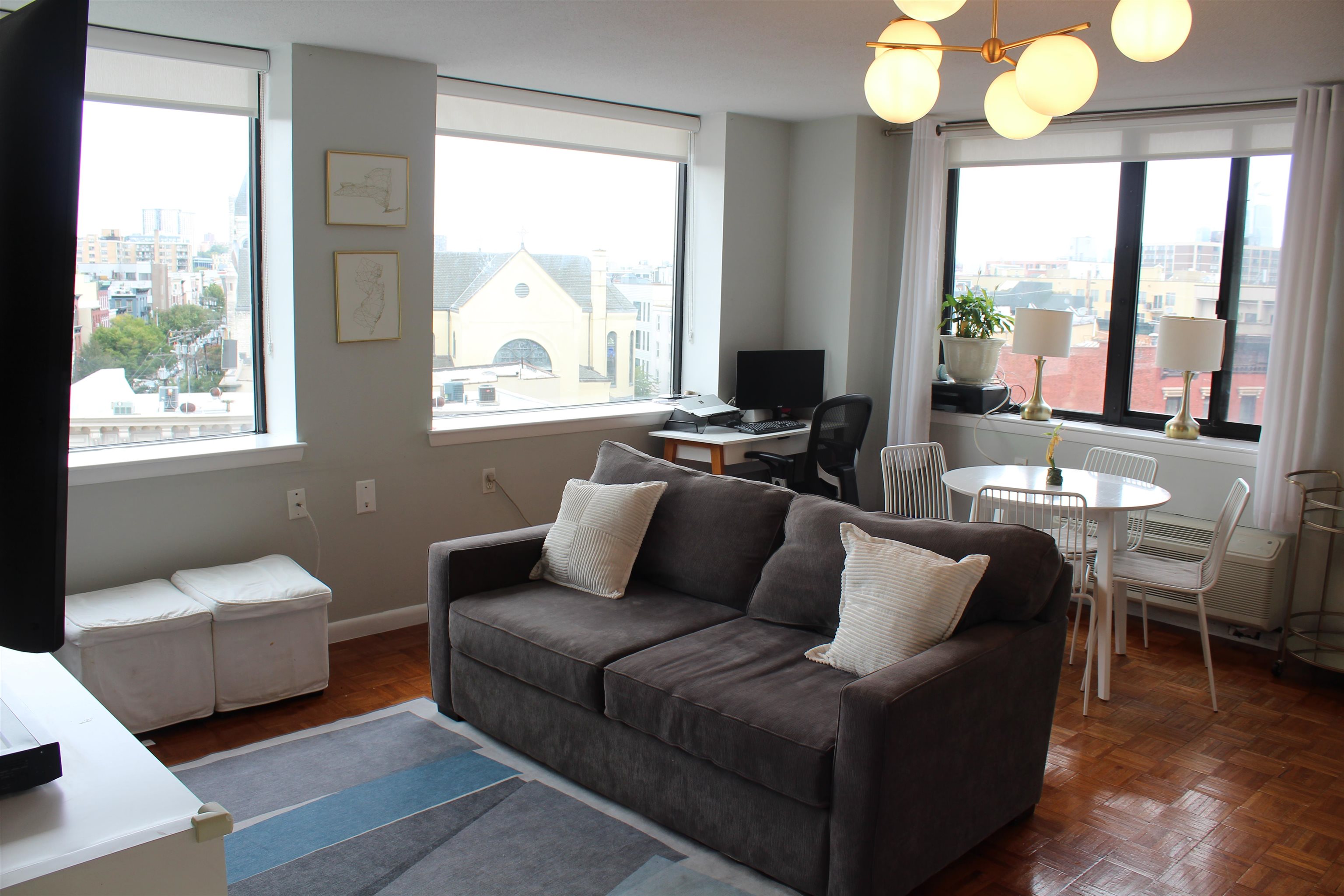 a living room with furniture and a large mirror next to a window