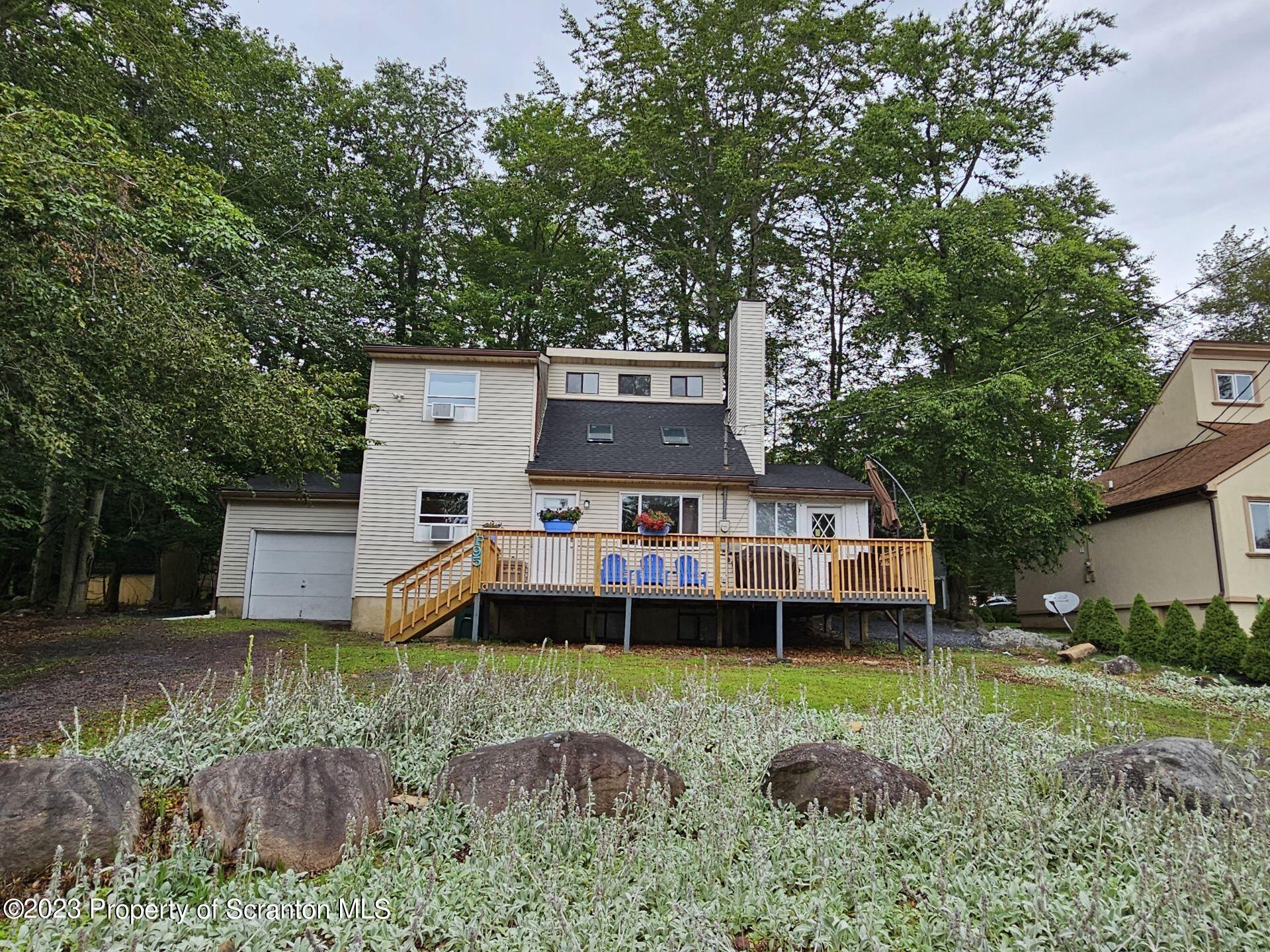 a view of a house with a big yard and large trees