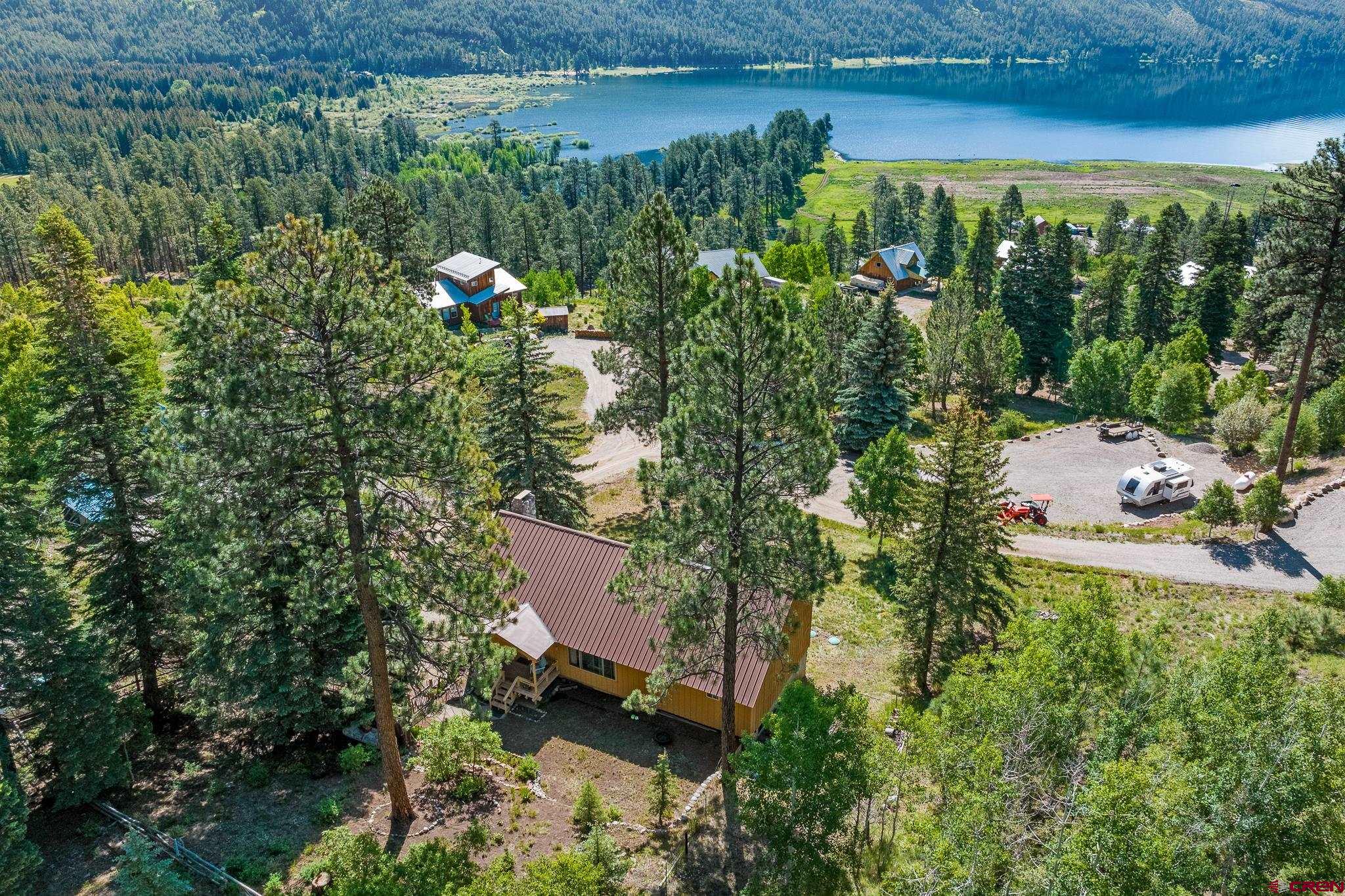 an aerial view of a house with a yard lake house and outdoor seating