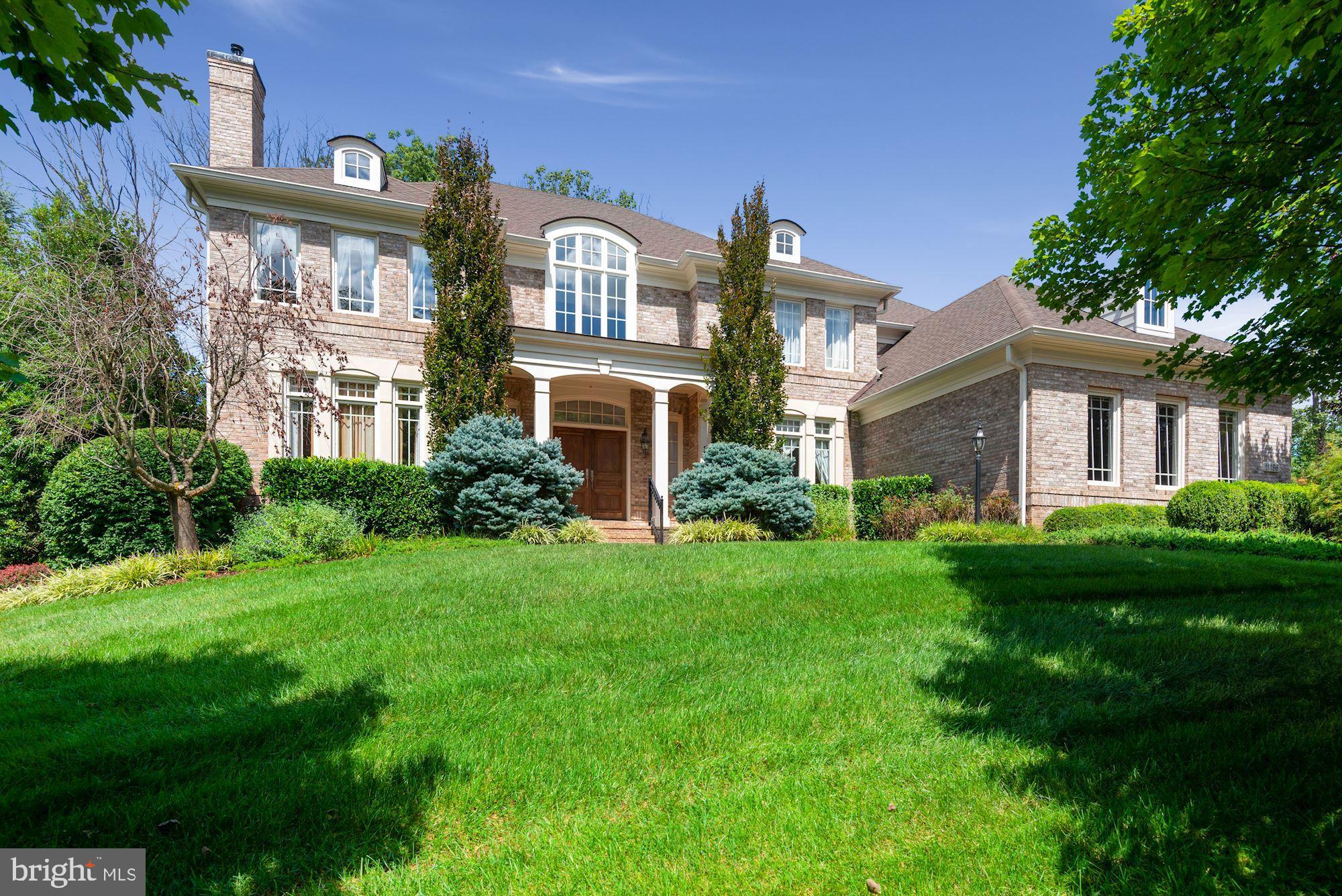 a front view of a house with a yard and trees