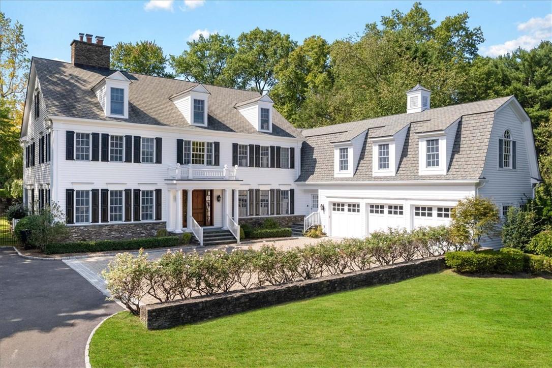 Cape cod house featuring a front lawn and a garage