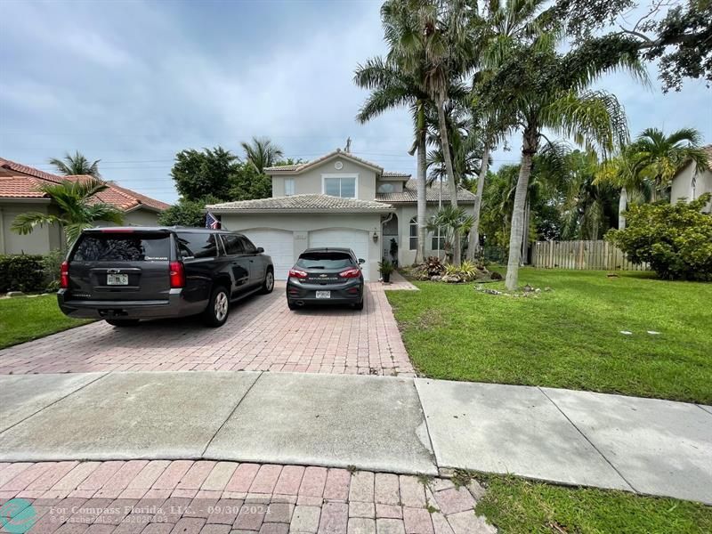 a view of a car parked in front of a house with cars parked