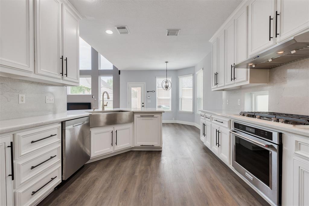 a kitchen with granite countertop a stove top oven and cabinets