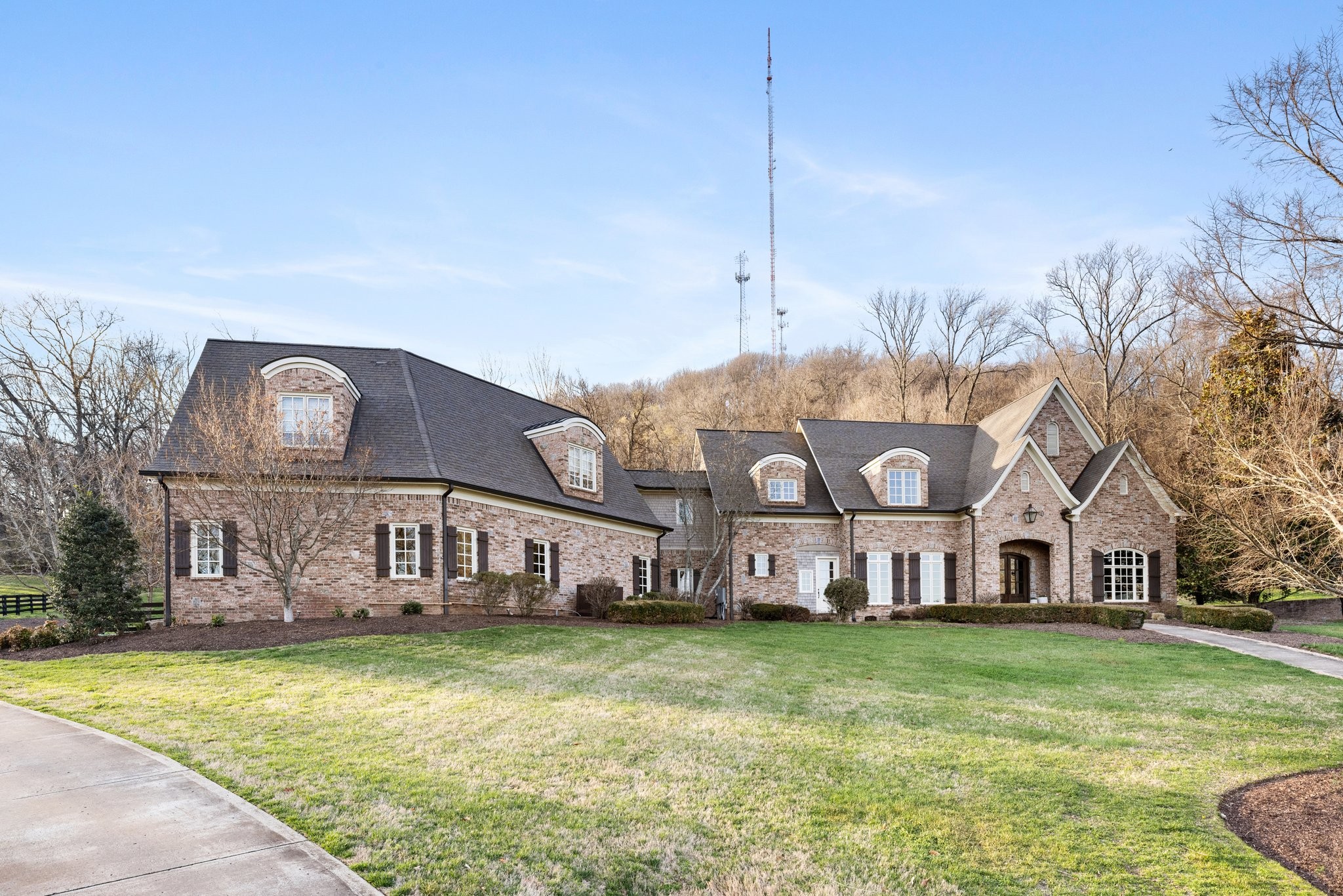 a view of a house with a big yard and large trees