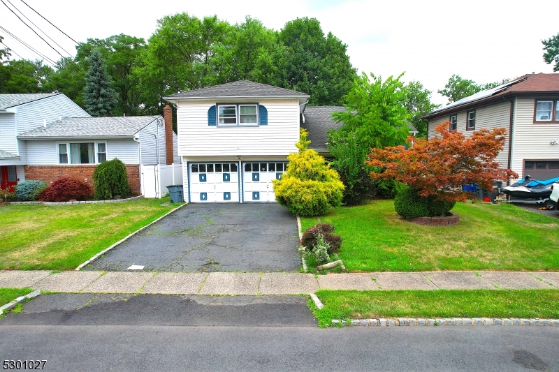 a front view of a house with a garden and trees