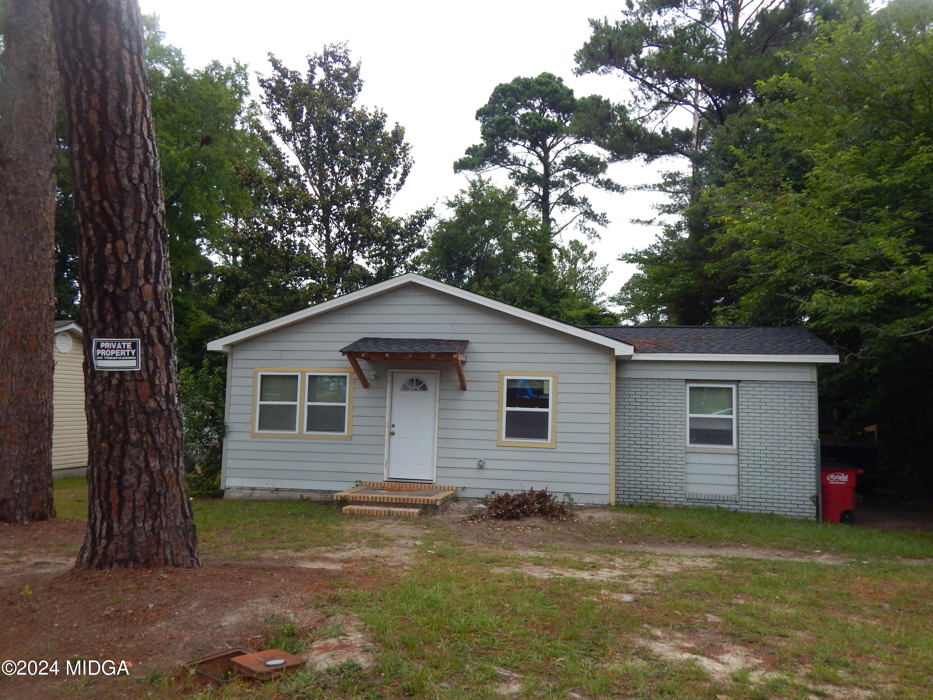 a view of a yard in front of a house with large tree