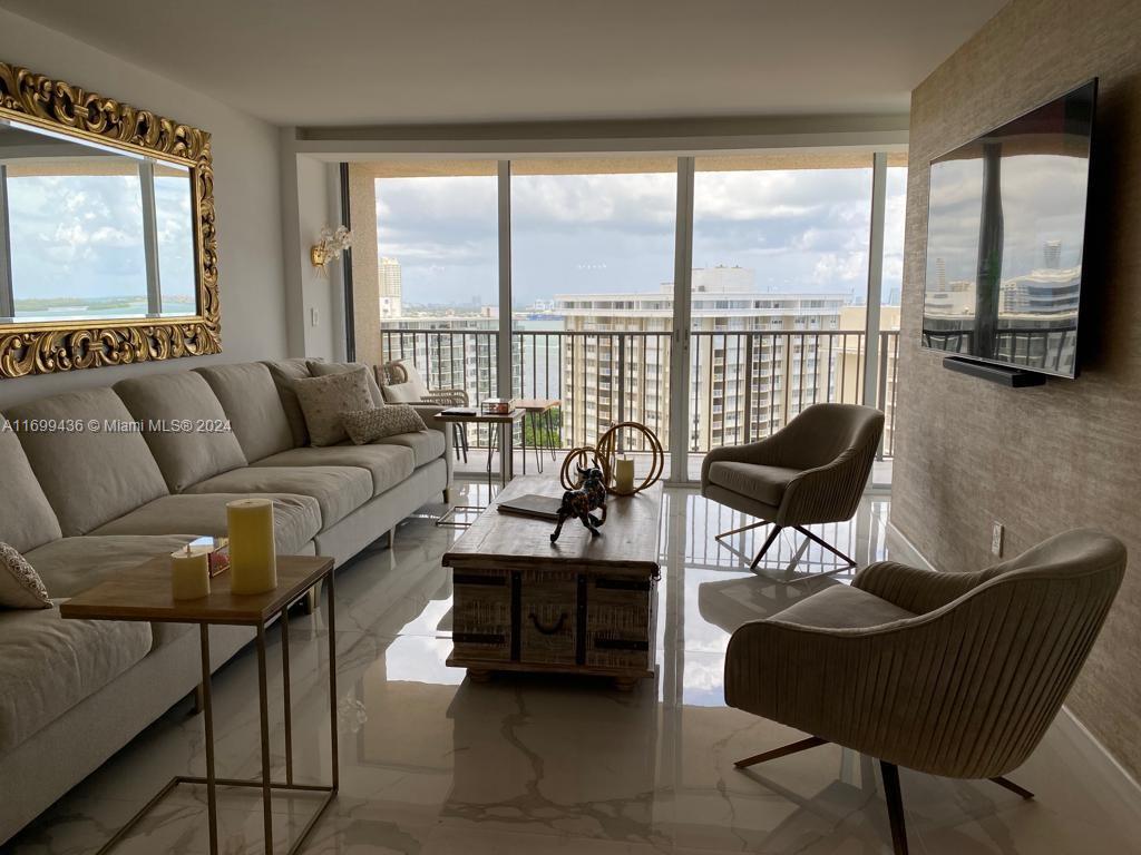 a living room with furniture and a floor to ceiling window