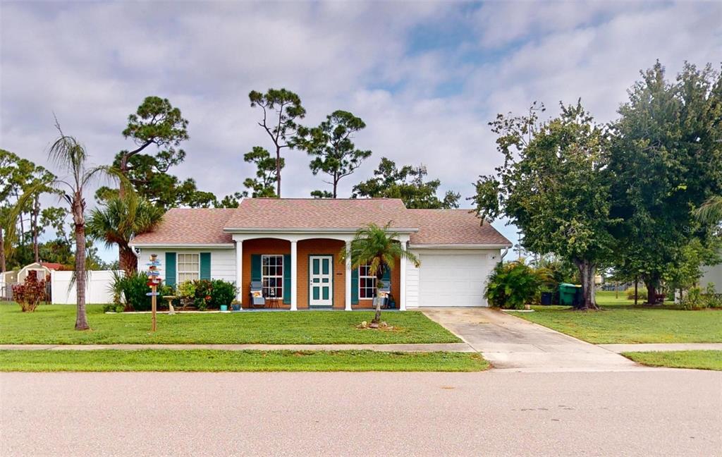 a front view of a house with a yard and potted plants