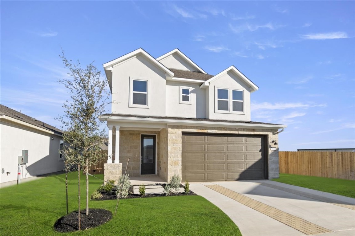 a front view of a house with a yard and garage