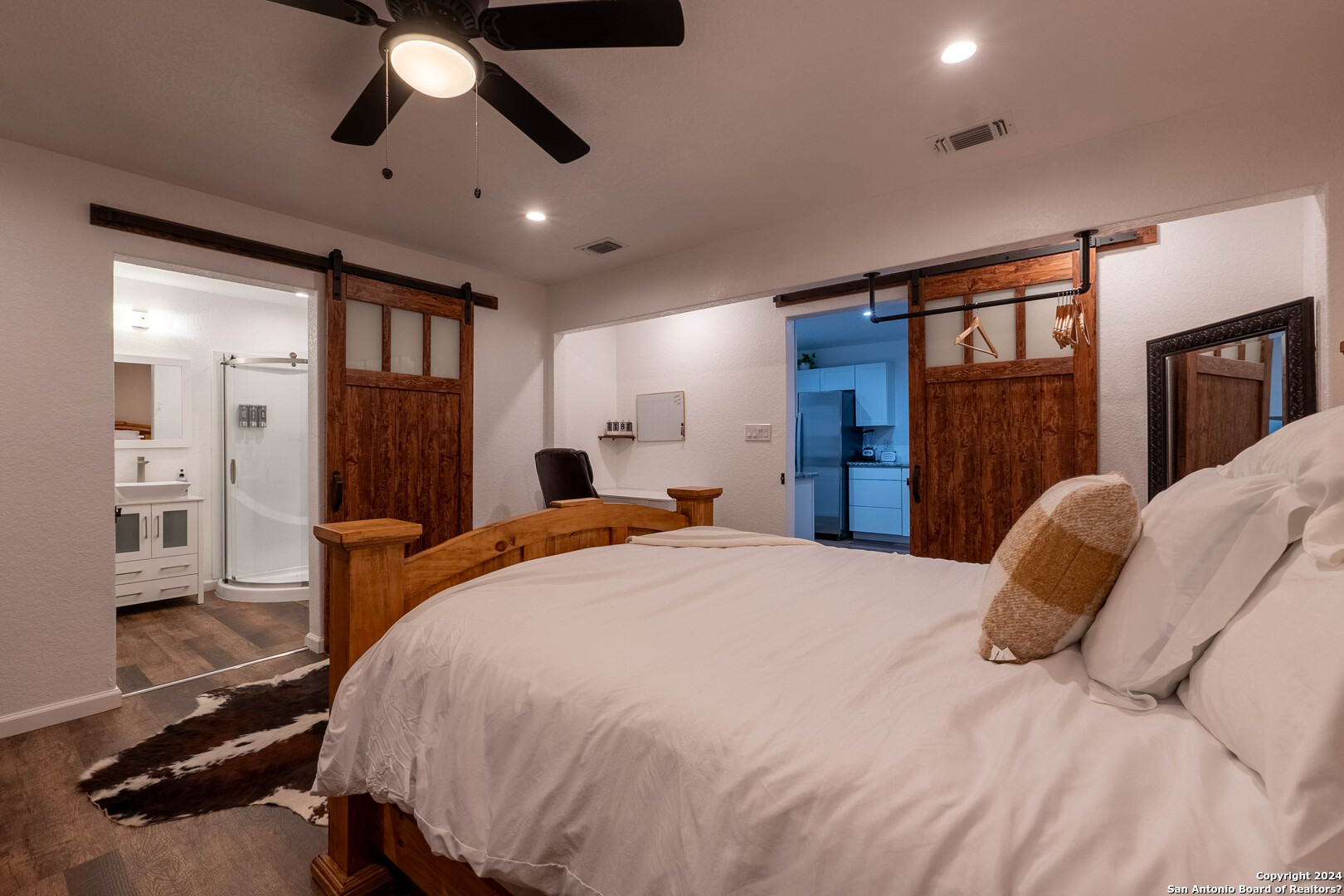 a bed room with a bed mirror and a chandelier