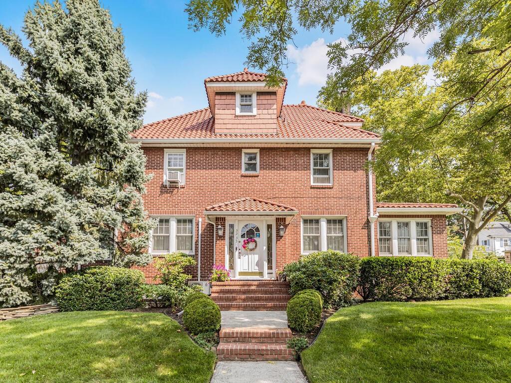 Center Hall Colonial  spanish-style roof with a front lawn