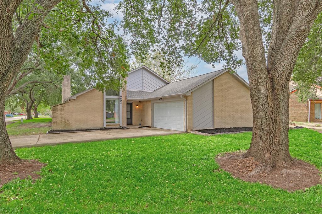 a front view of a house with a yard and tree