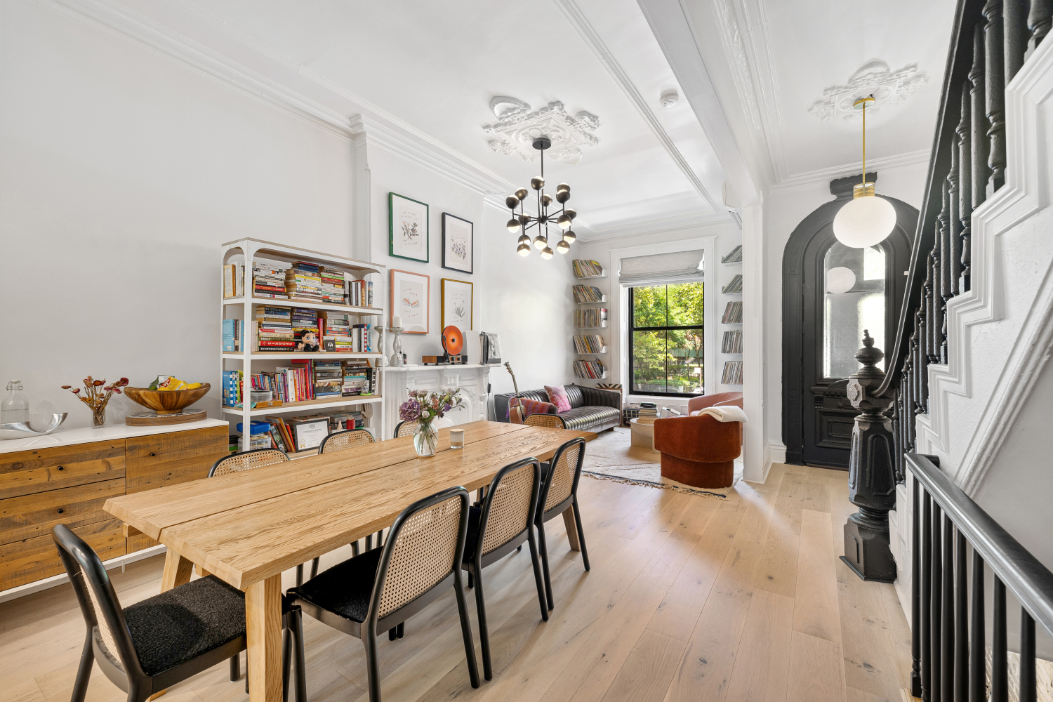 a dining room with wooden floor a chandelier a wooden table and chairs