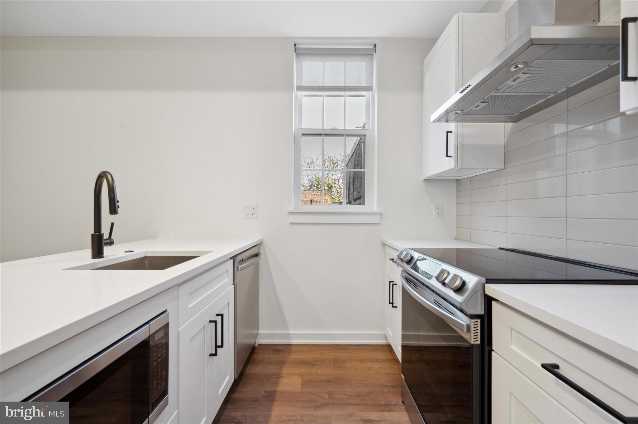 a kitchen with a sink stove and cabinets