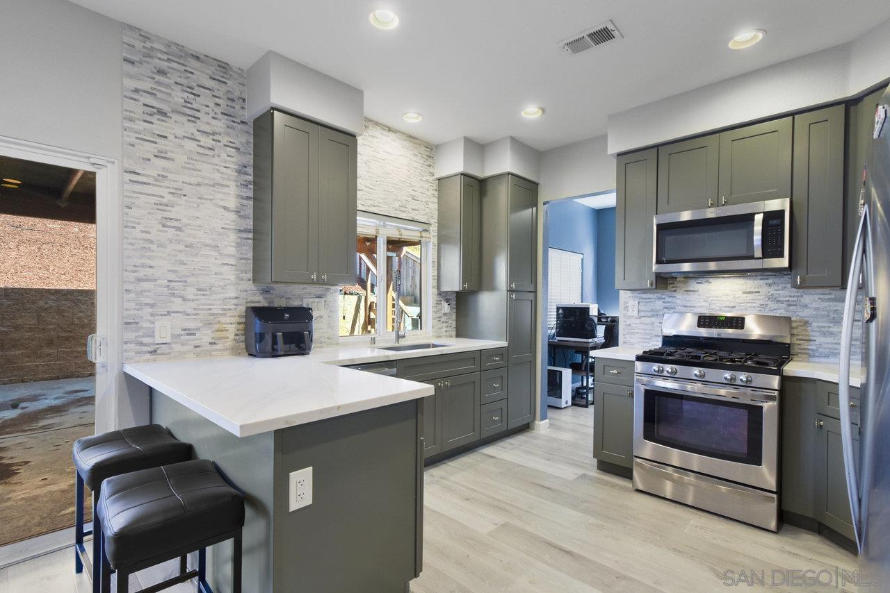 a kitchen with stainless steel appliances a stove sink microwave and refrigerator