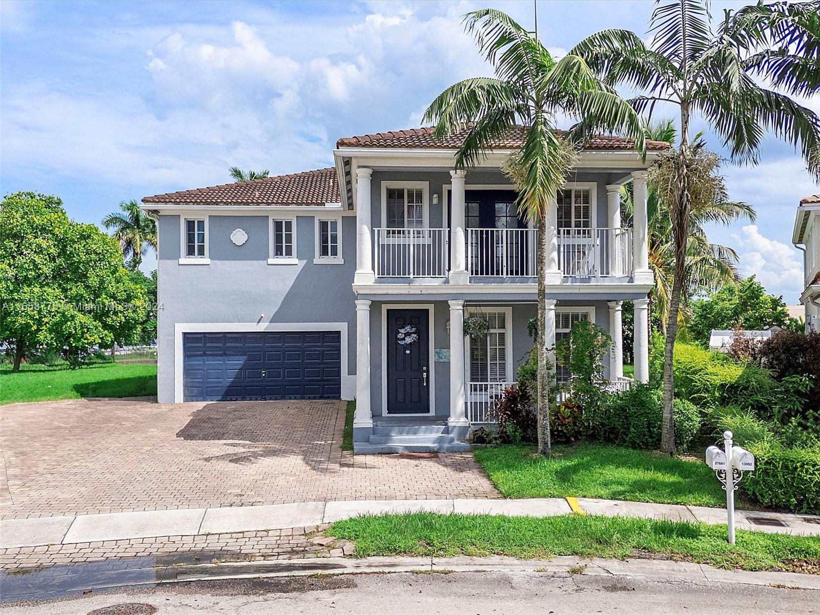 a front view of a house with a yard and potted plants