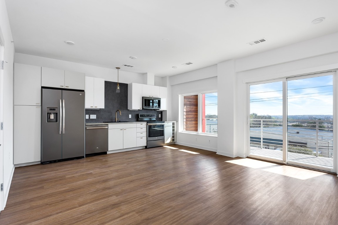 a view of kitchen with granite countertop cabinets and refrigerator