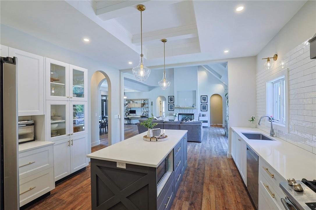 Kitchen featuring white cabinets, pendant lighting, dark hardwood / wood-style flooring, and sink