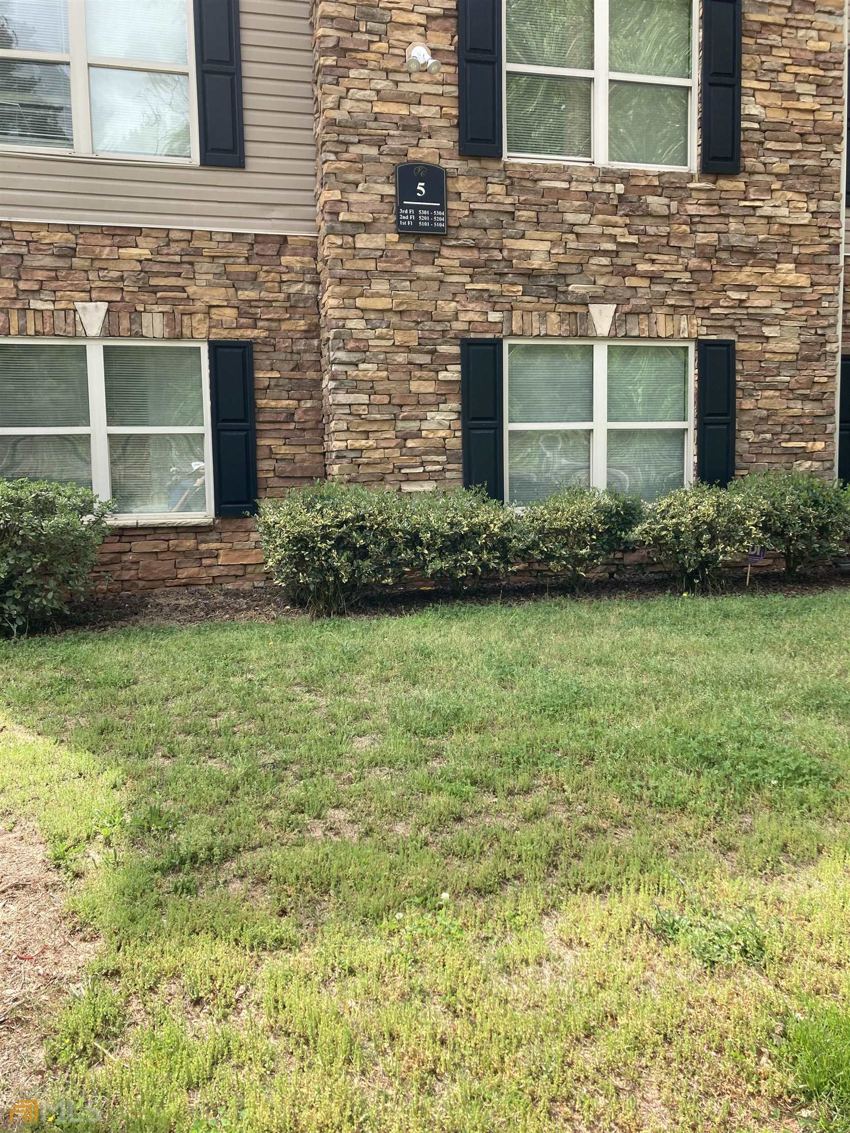 a front view of a house with a garden and yard