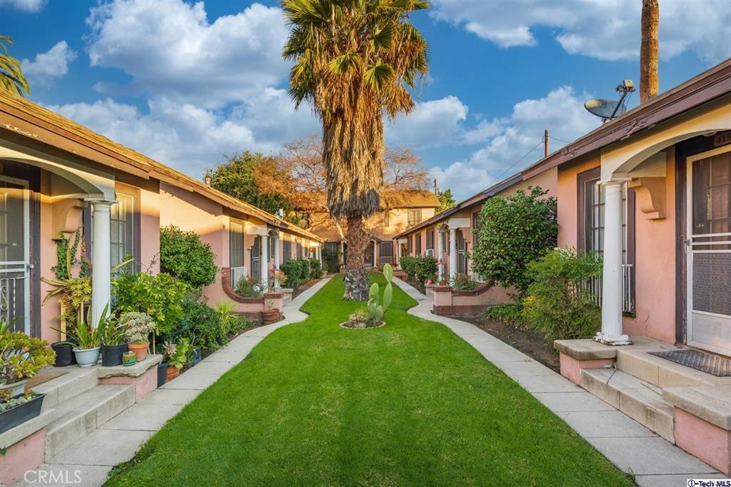 a view of a house with a big yard and potted plants