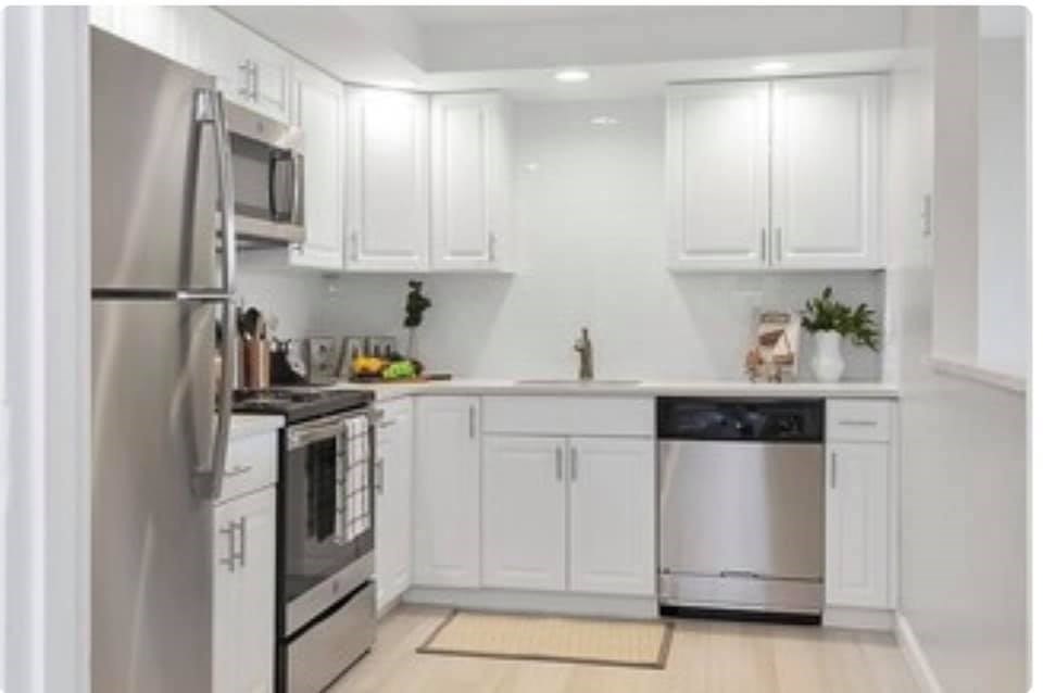 a kitchen with white cabinets and white appliances