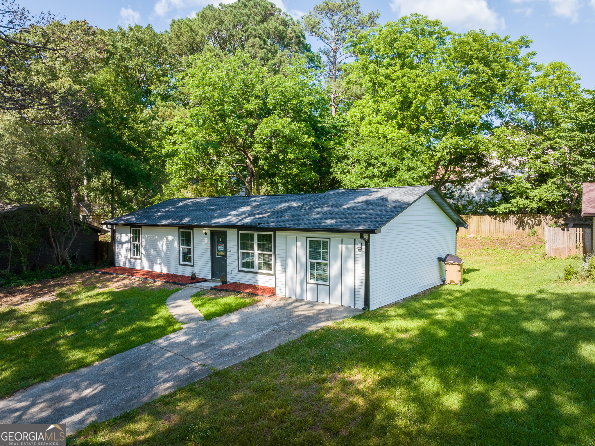 a view of a house with a yard and tree s