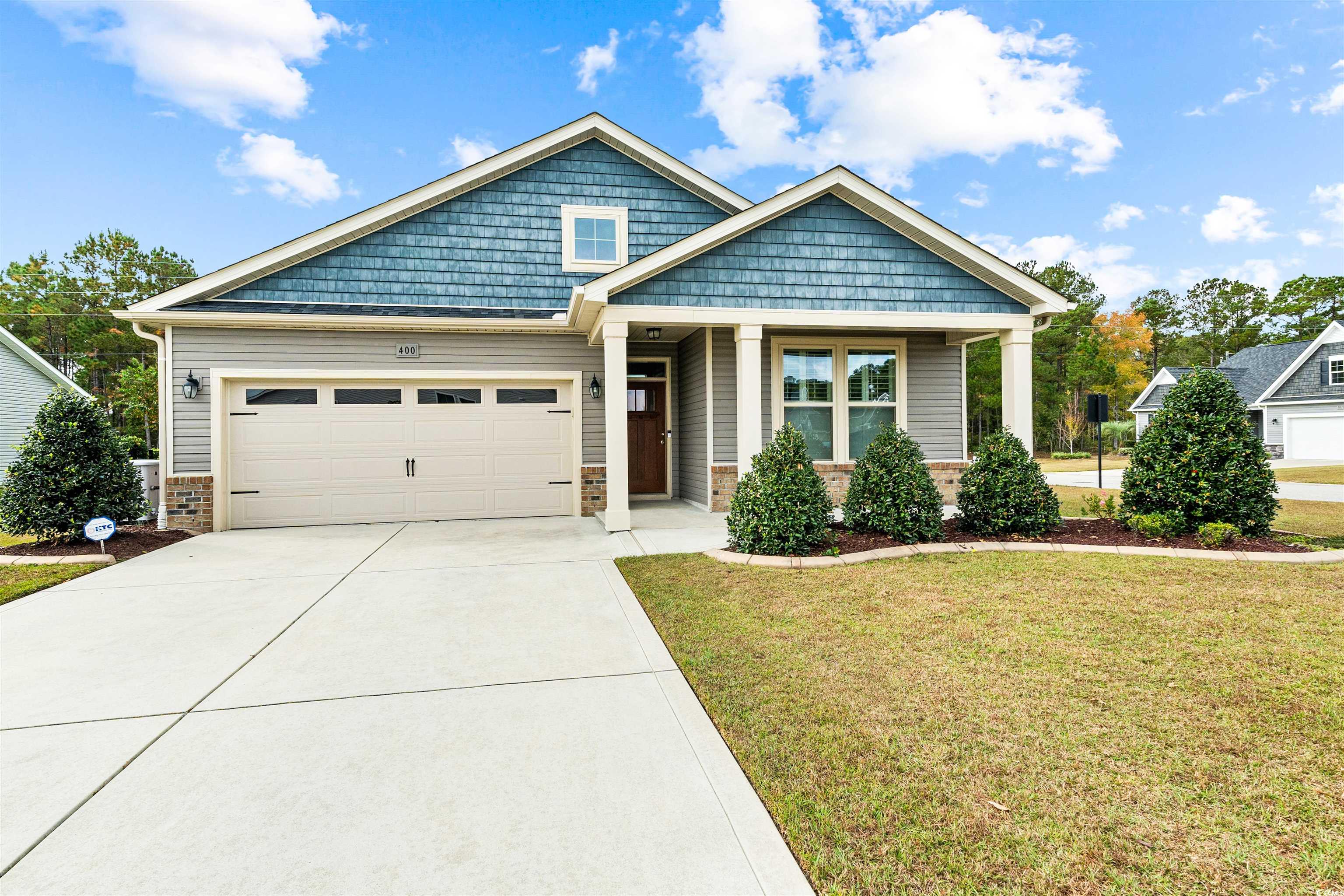 Craftsman house with a garage and a front yard