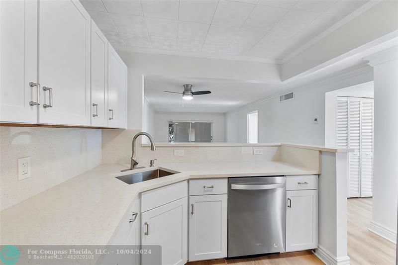 a kitchen with white cabinets and sink