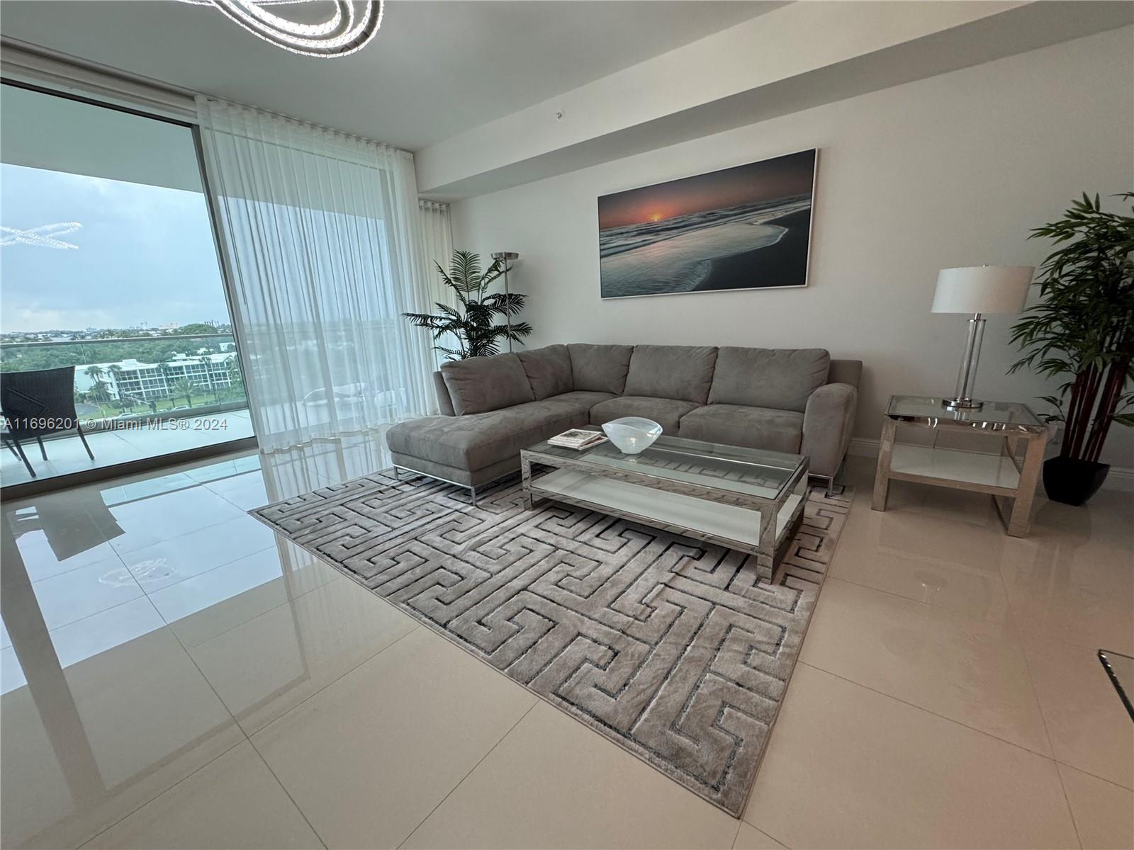 a living room with furniture and a floor to ceiling window