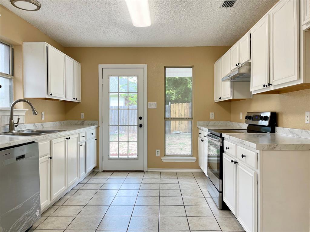 a kitchen with a stove top oven sink and cabinets