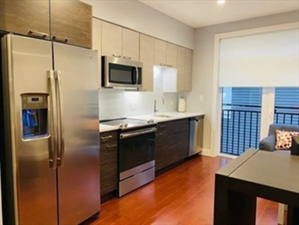 a kitchen with stainless steel appliances a refrigerator and a stove top oven