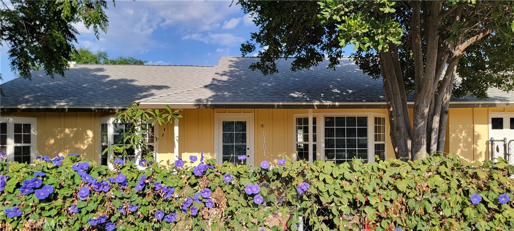 front view of house with a lot of flowers