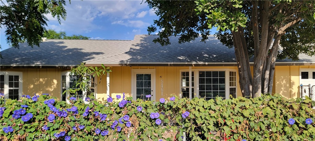 front view of house with a lot of flowers