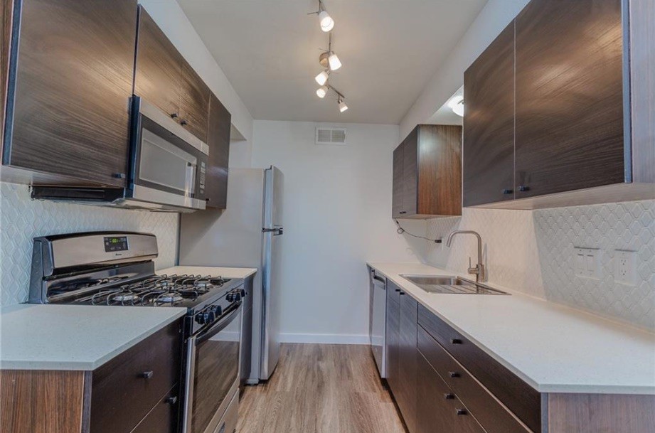 a kitchen with stainless steel appliances sink stove microwave and cabinets