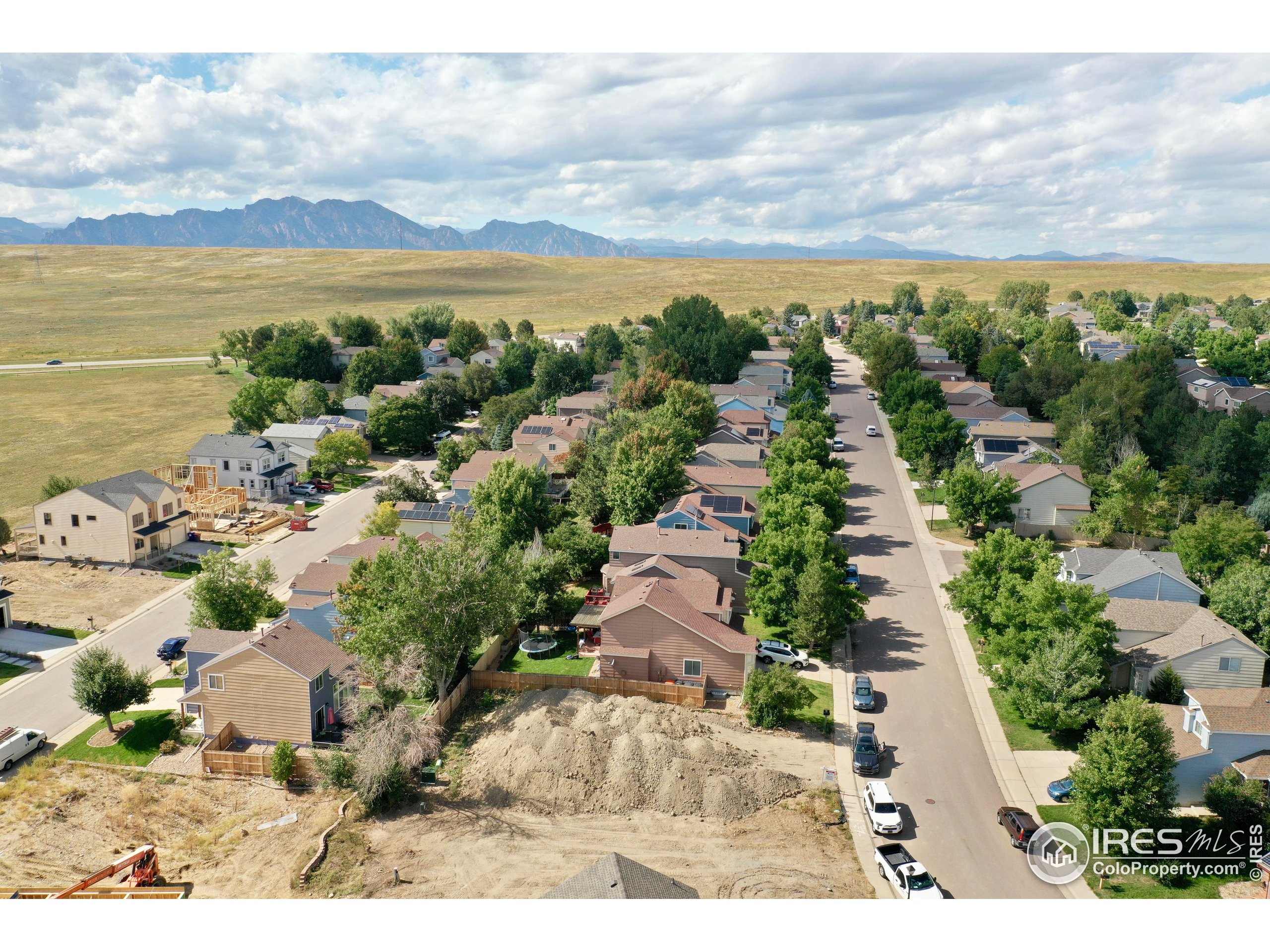 an aerial view of a city with lots of residential buildings ocean and mountain view in back