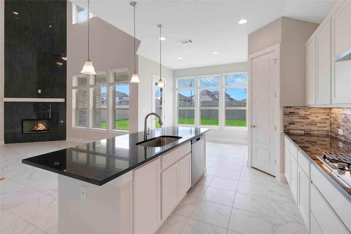 a kitchen with granite countertop a sink a counter top space appliances and cabinets