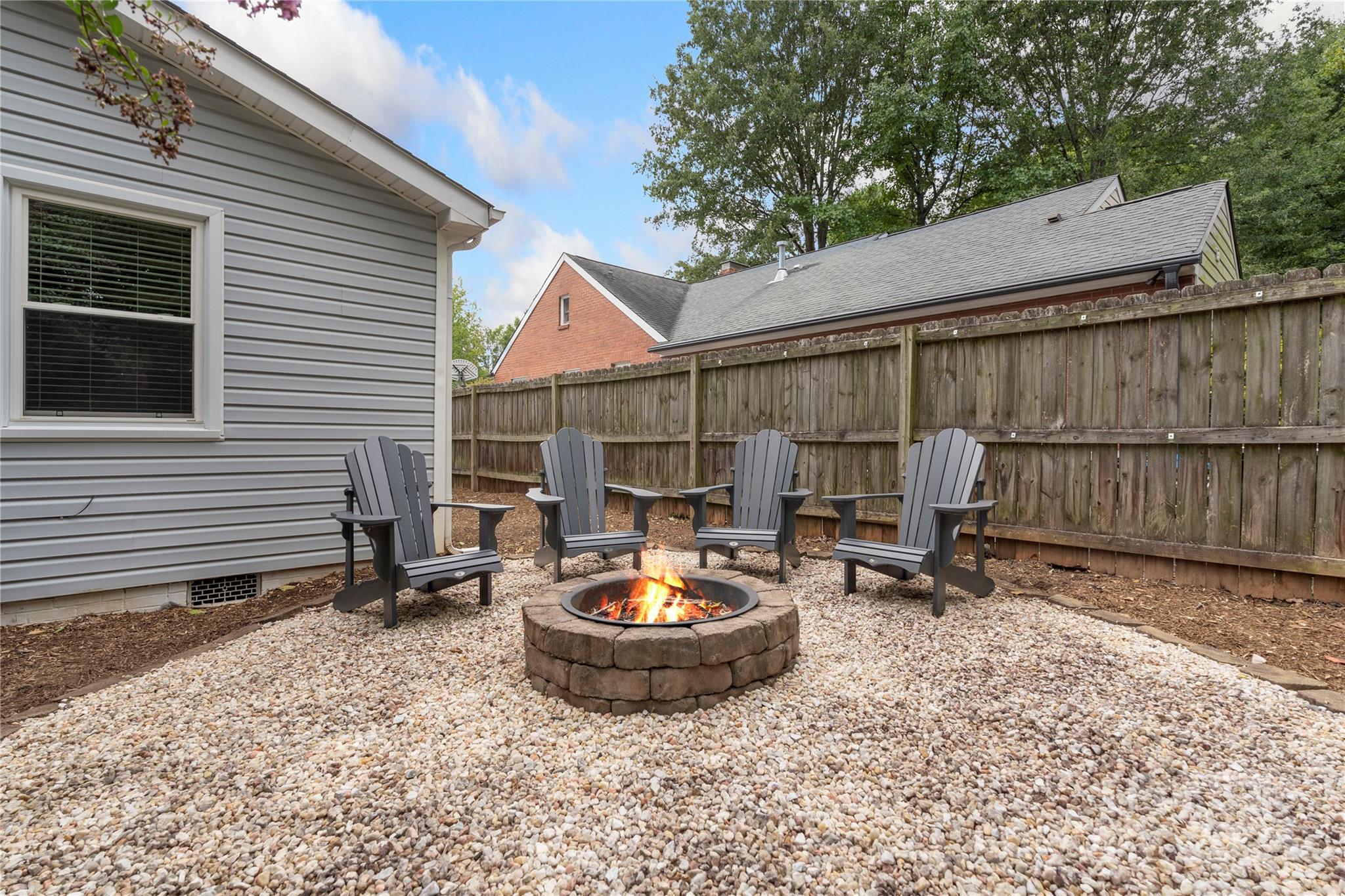 a view of a backyard with table and chairs and a barbeque