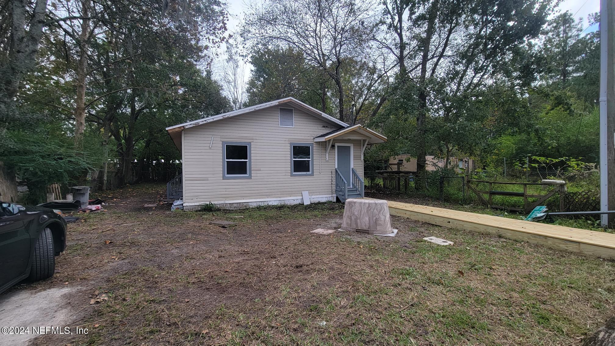 a view of a house with backyard and trees