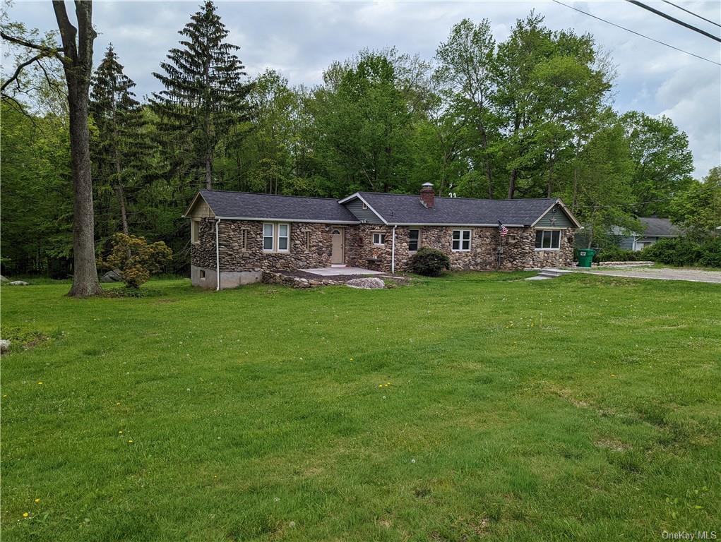 a view of a house with a yard and sitting area