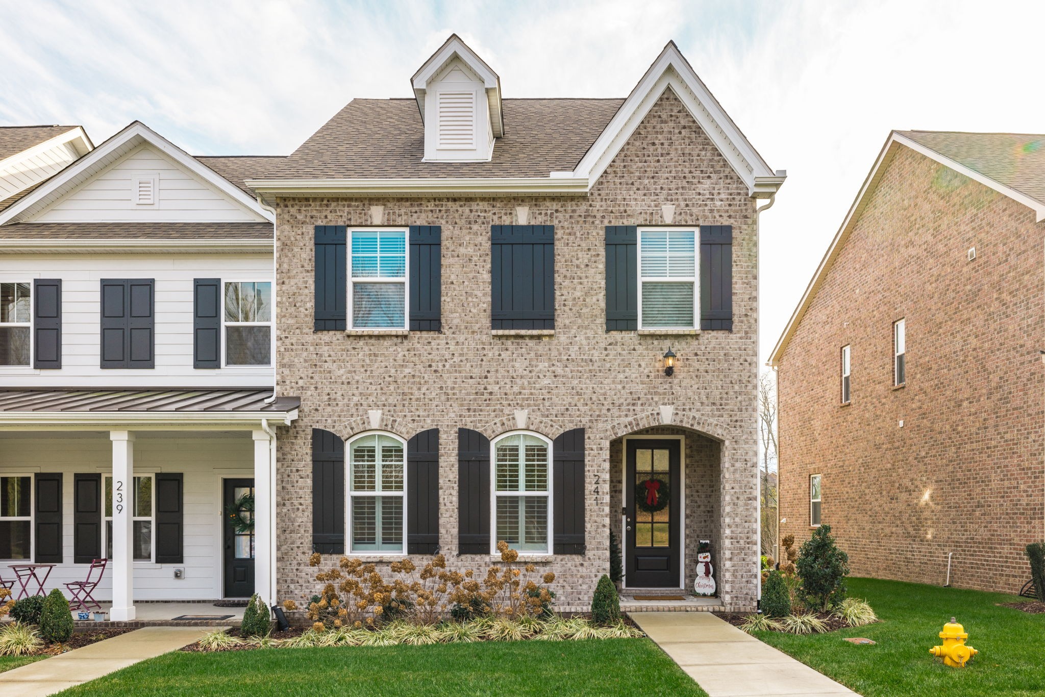 front view of a brick house with a yard