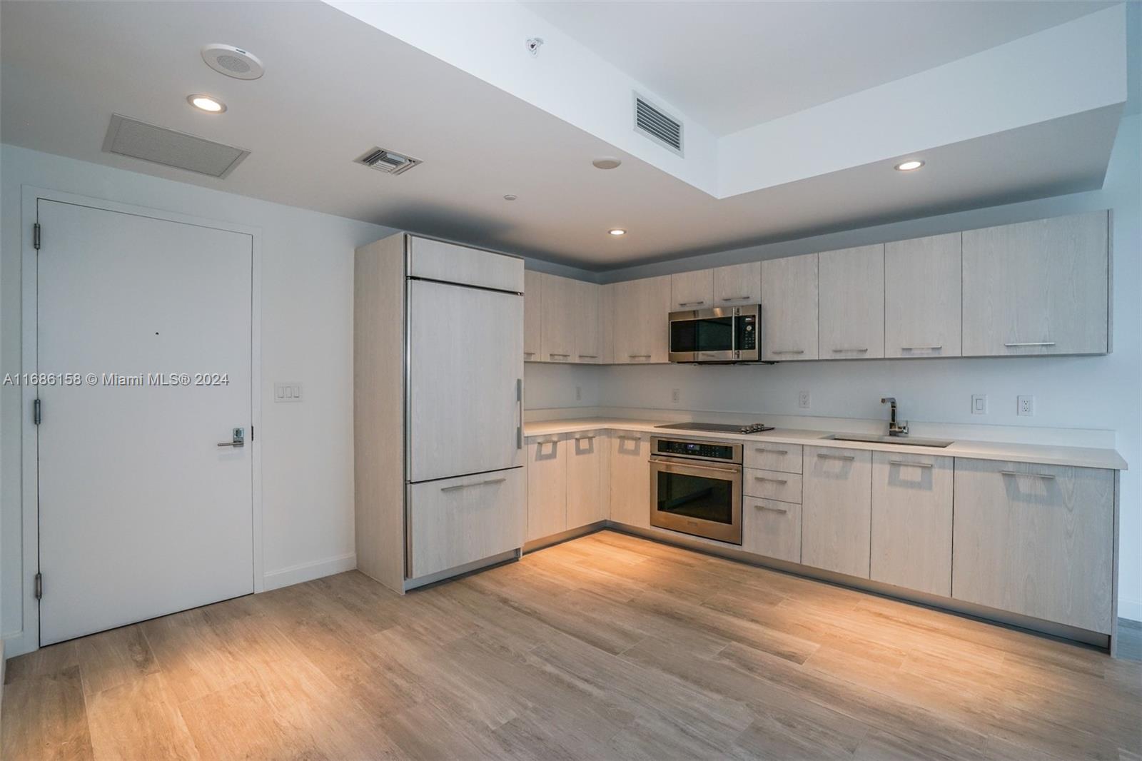 a kitchen with stainless steel appliances granite countertop a refrigerator and a stove top oven