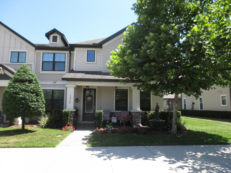 a front view of a house with a garden and trees