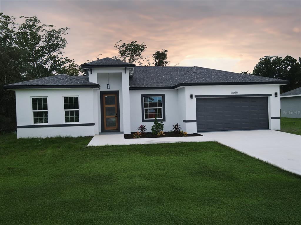 a front view of a house with a garden and yard