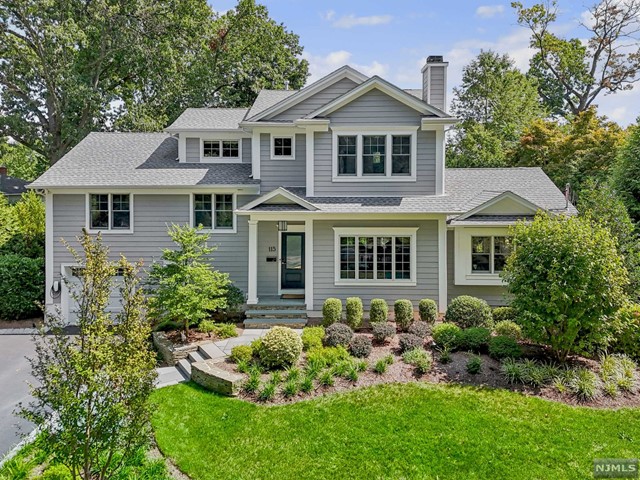 a front view of a house with a yard and trees