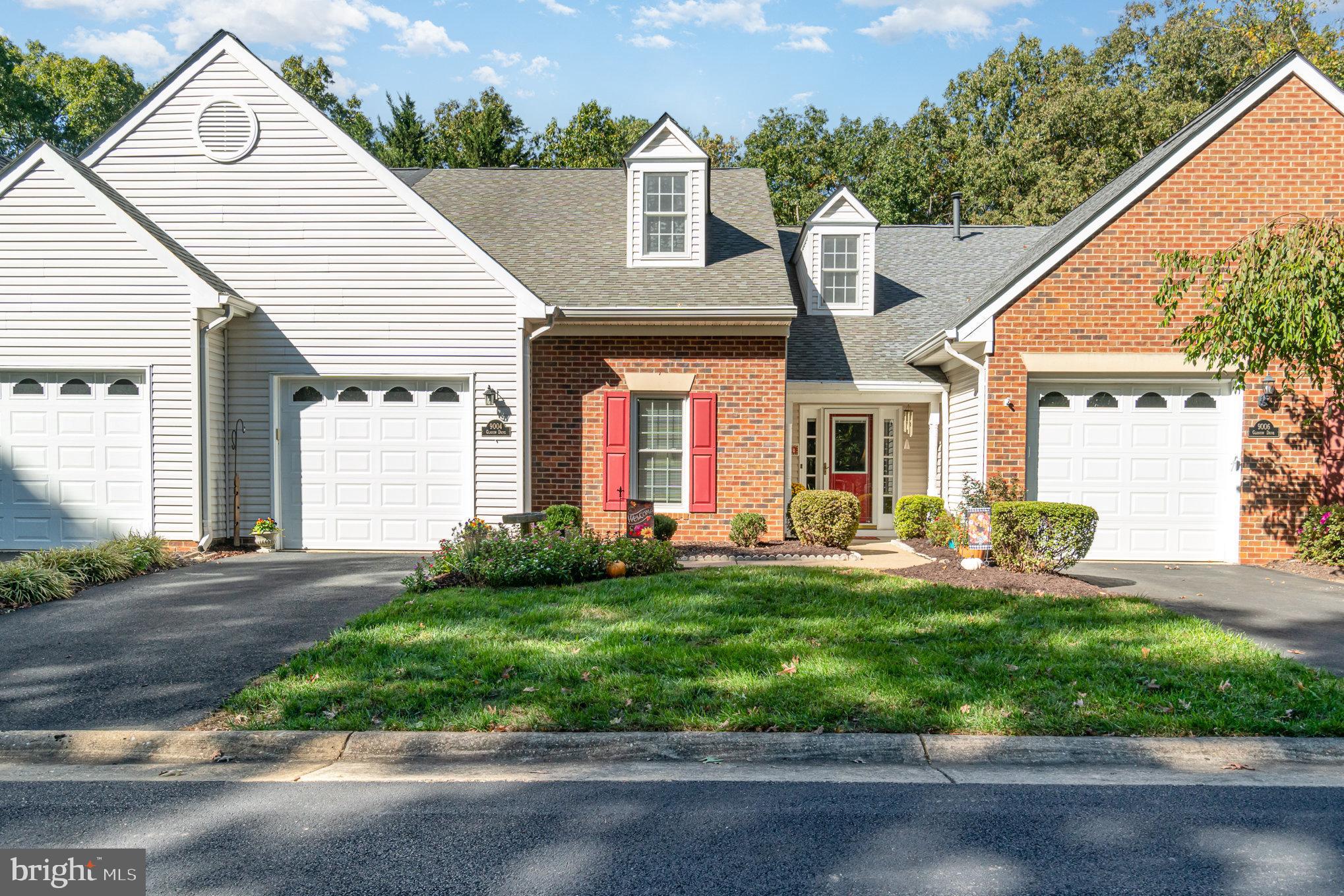 a front view of a house with yard and green space