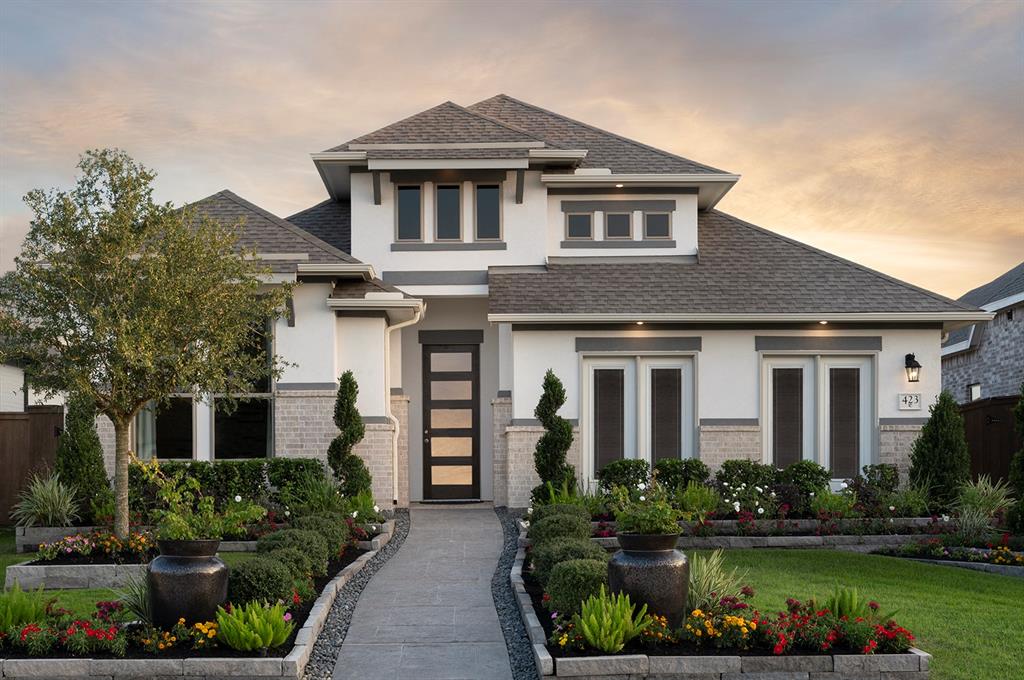 a front view of a house with a yard and potted plants